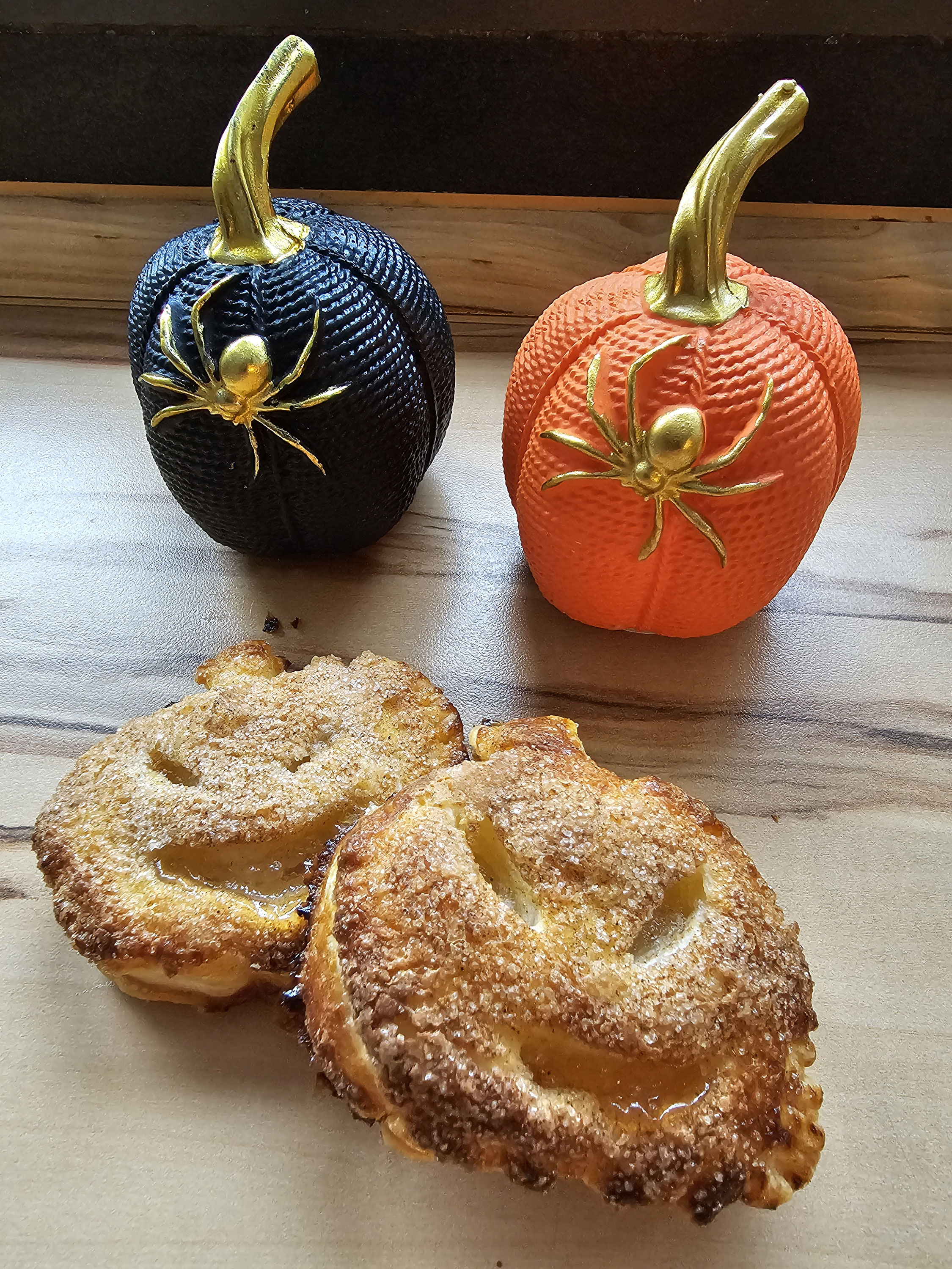 Goldbraune Apfeltaschen mit Halloween-Gesichtern.