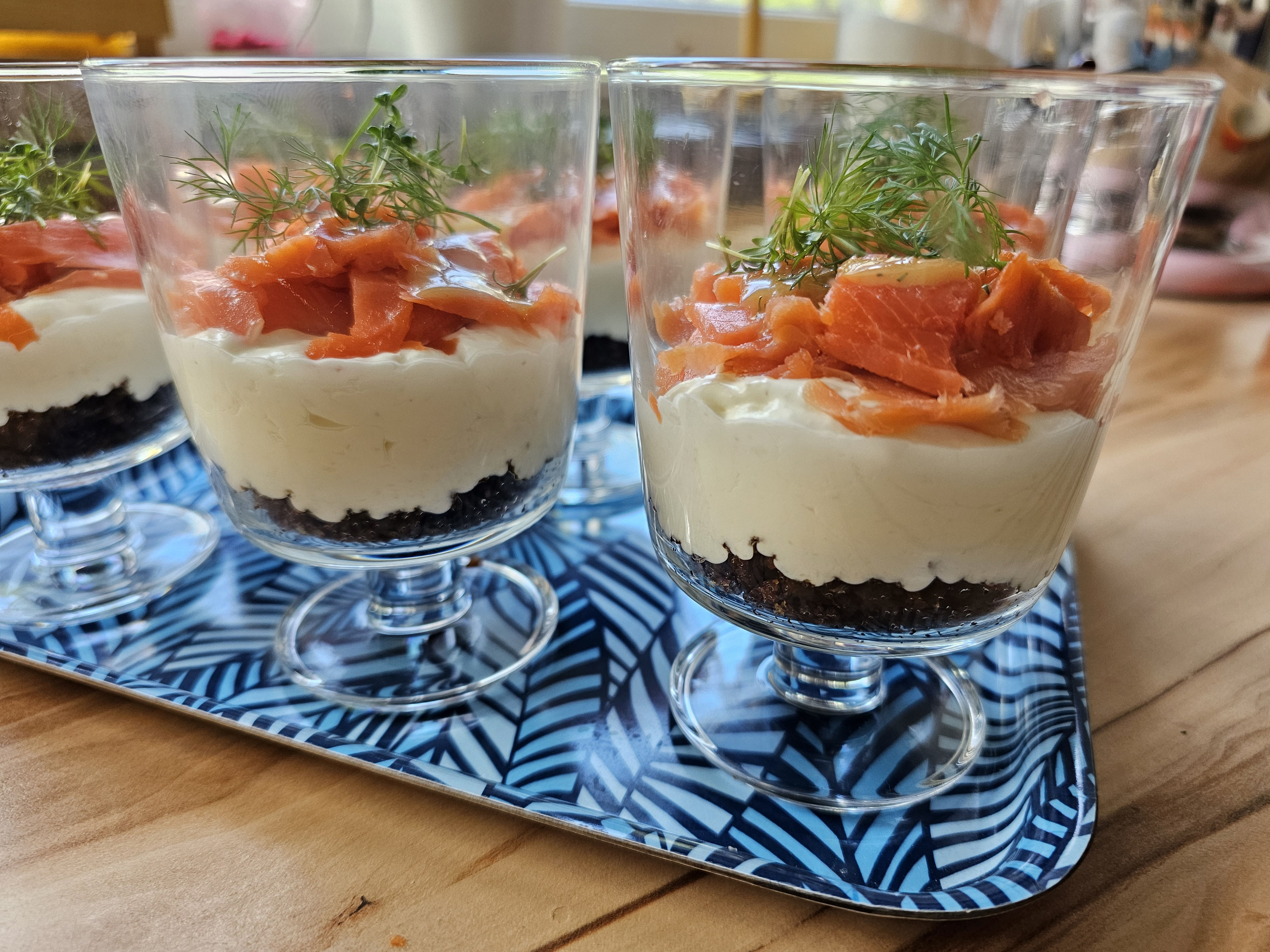 Lachs-Trifle im Glas mit Honig-Senf-Sauce und Kresse.