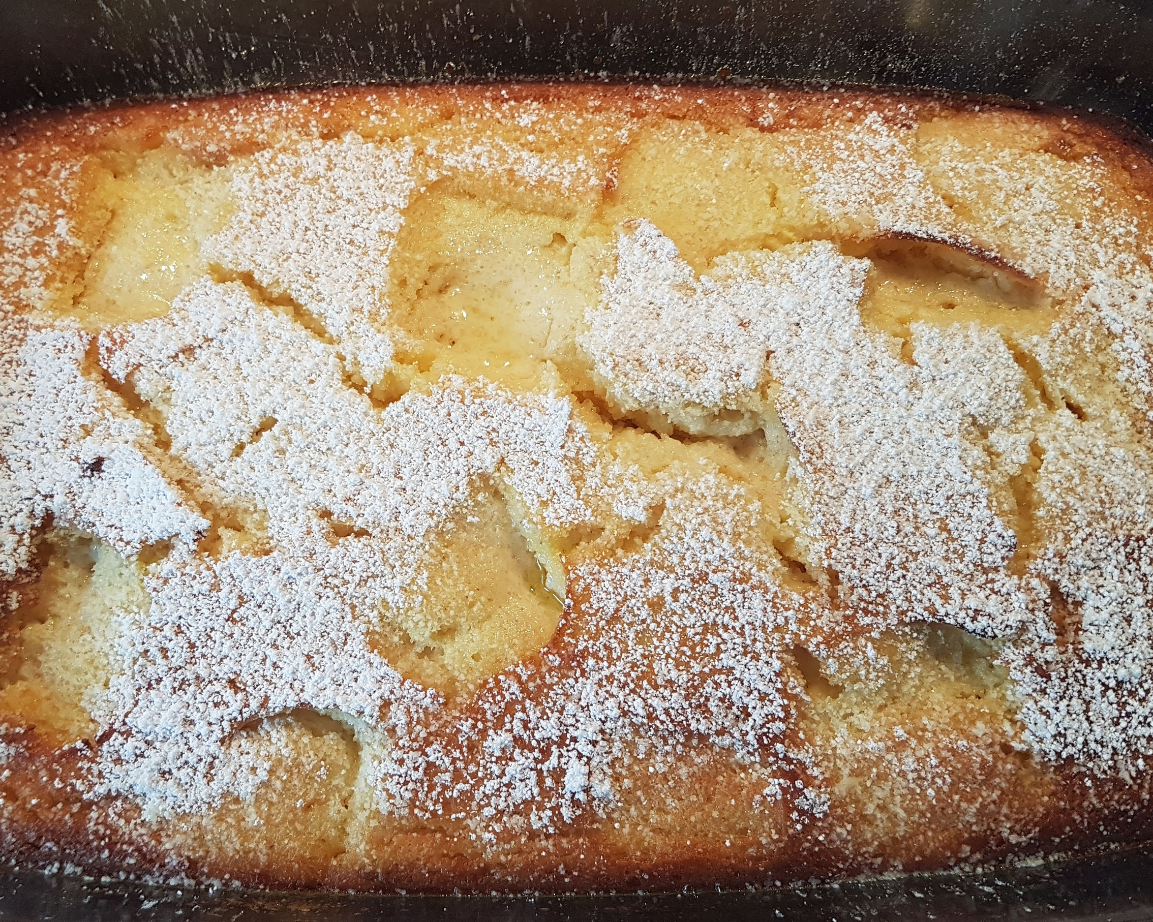 Goldbrauner Apfel-Quarkauflauf mit Puderzucker.