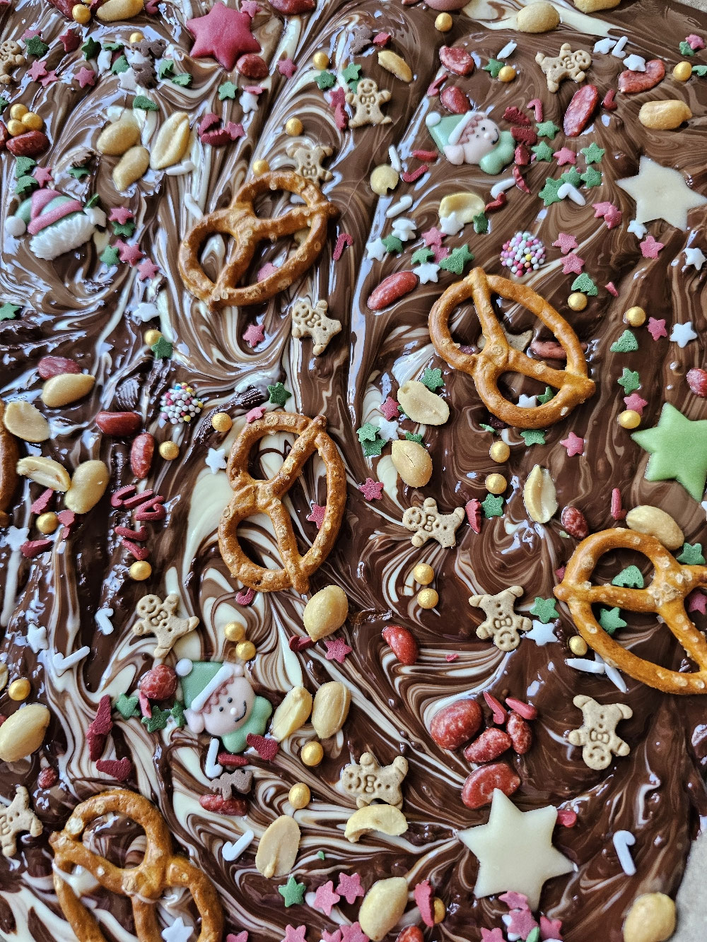 Marmorierte Weihnachts-Bruchschokolade mit bunten Toppings.