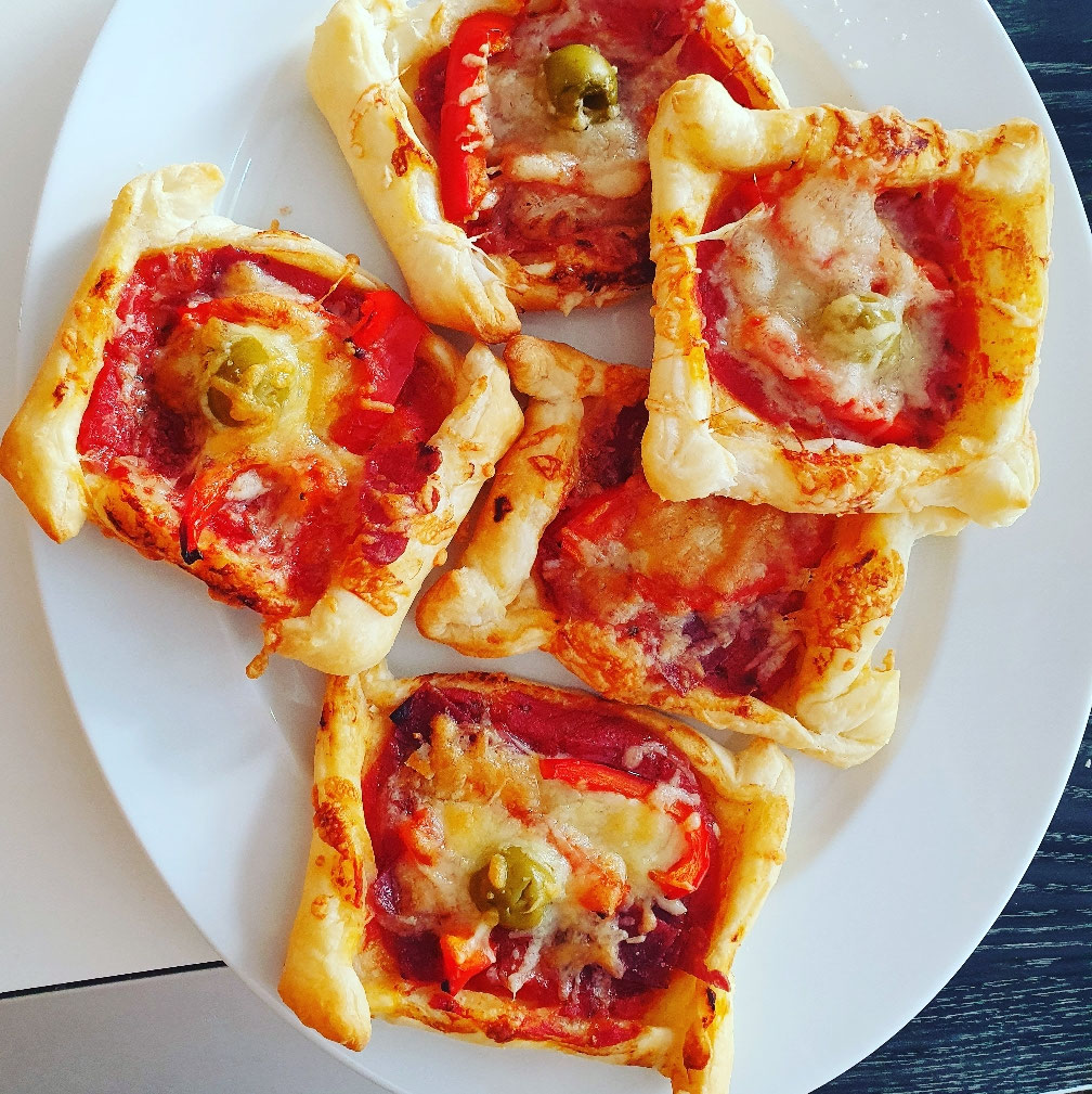 Knusprige Blätterteig-Pizzaecken mit Salami, Paprika, Oliven und Käse.