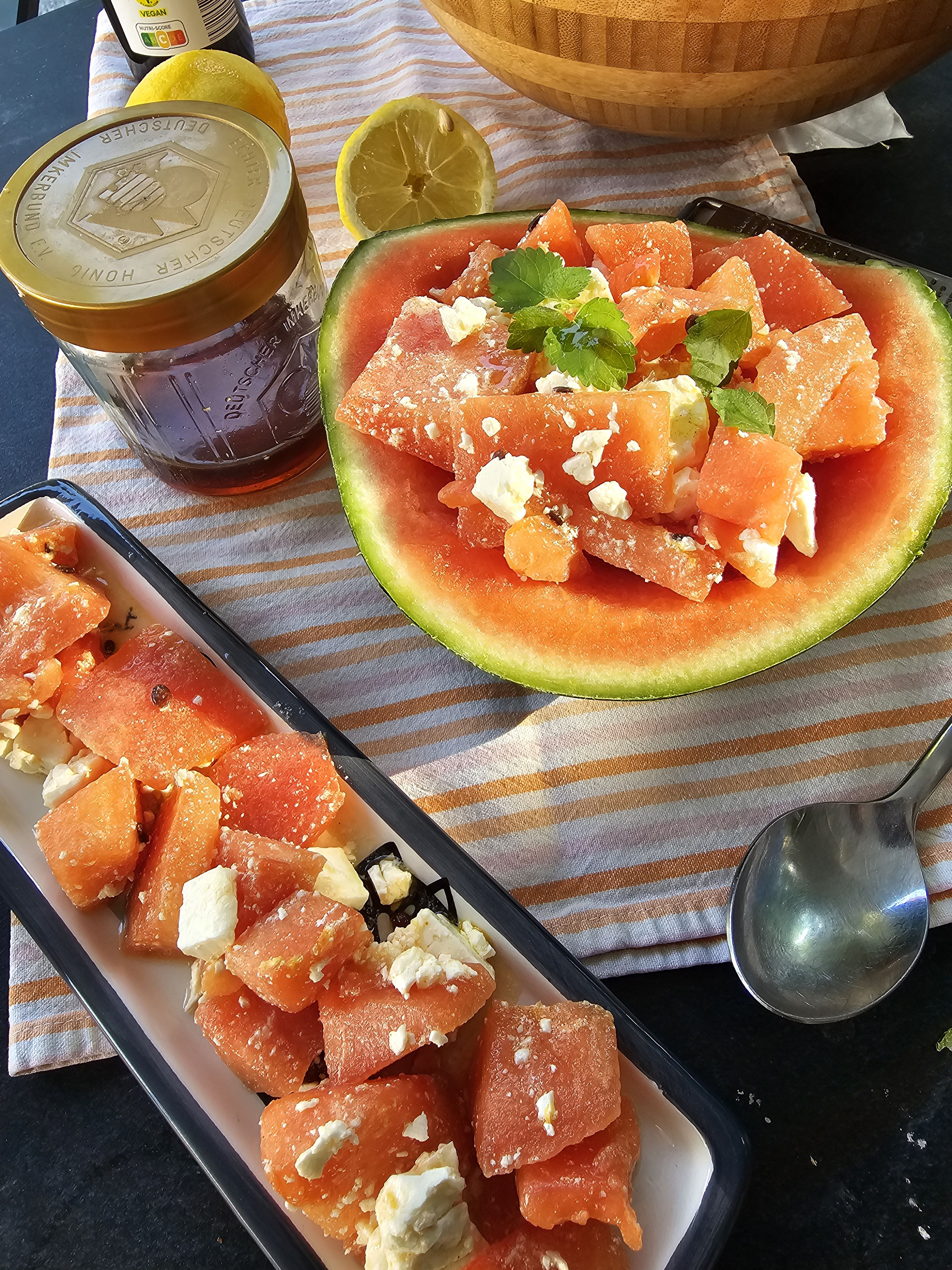 Wassermelonensalat mit Feta in einer ausgehöhlten Melonenhälfte.