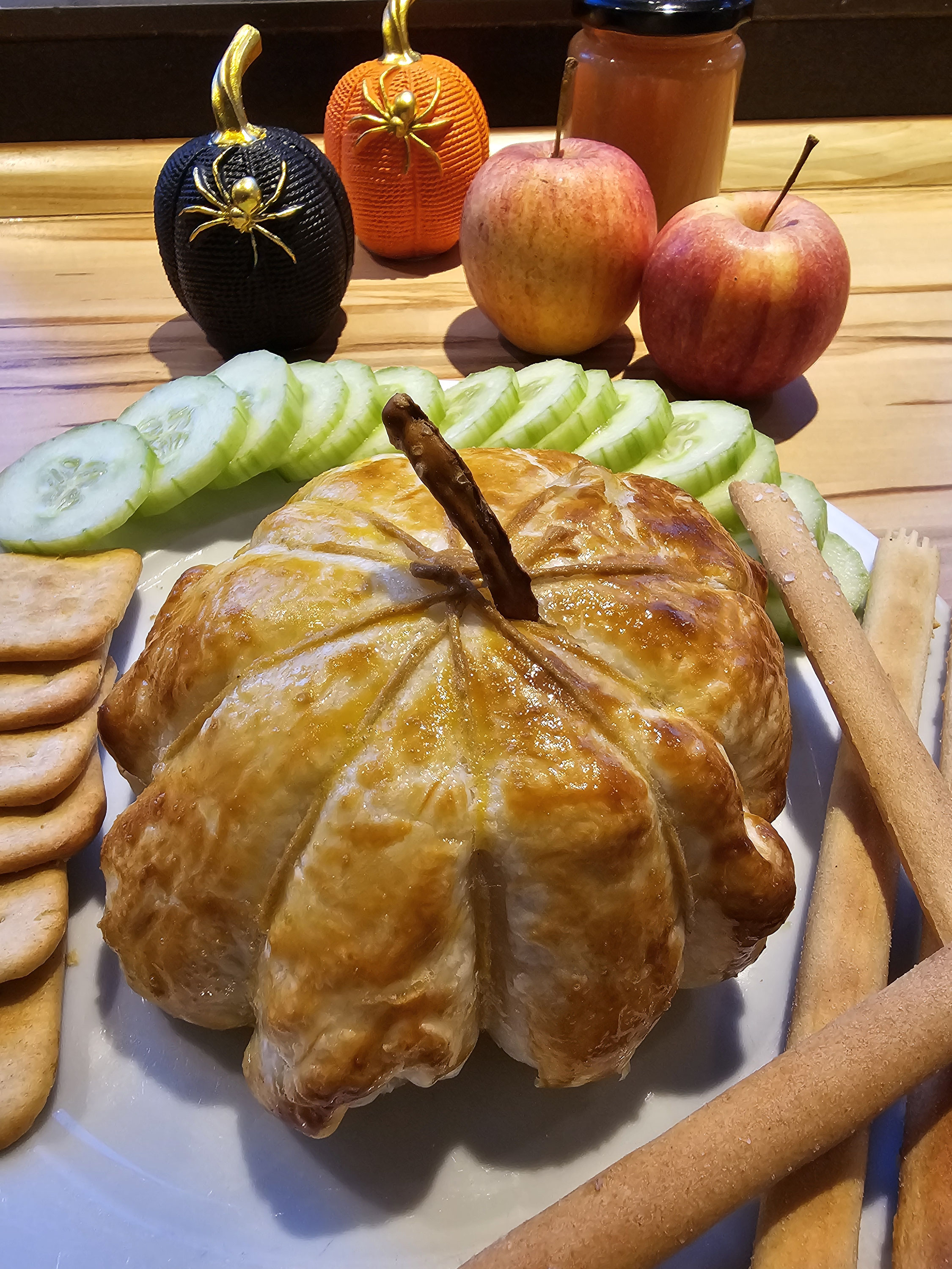 Goldbrauner Camembert im Blätterteig in Kürbisform.