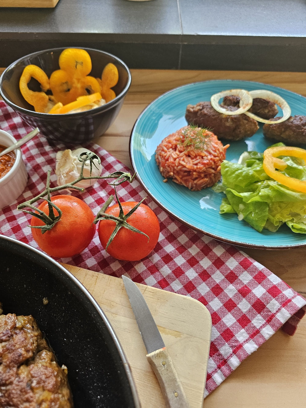 Cevapcici mit Ajvar und Zwiebeln auf einem Teller