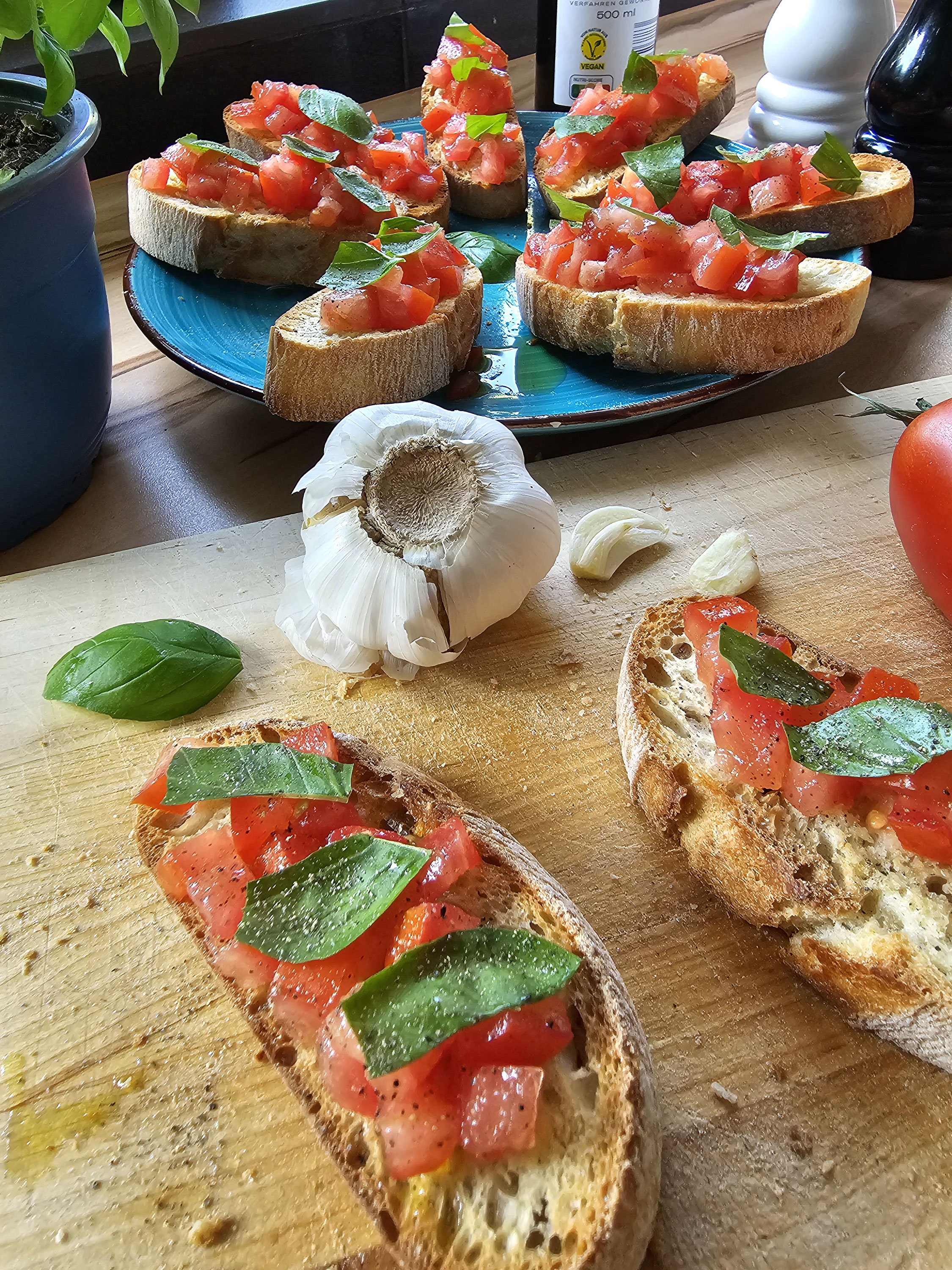 Bruschetta mit Tomaten und Basilikum, serviert auf Teller und Holzbrett.
