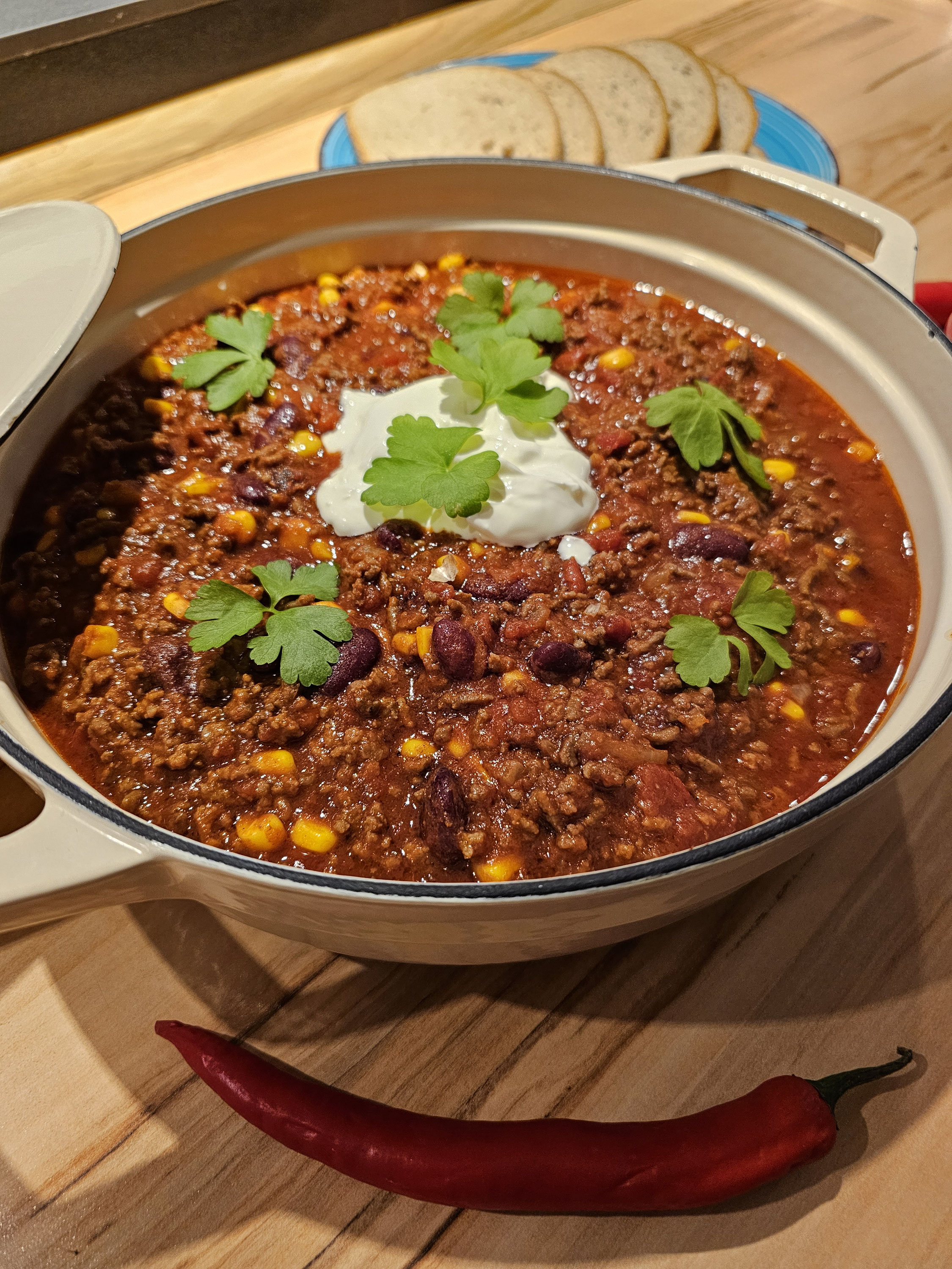 Chili con Carne mit Kidneybohnen und Mais, mit Beilagen als Serviervorschlag.