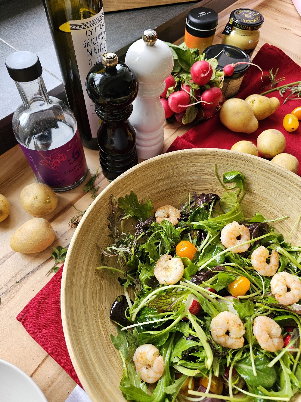 Wildkräutersalat mit Garnelen, Radieschen und gelben Tomaten.