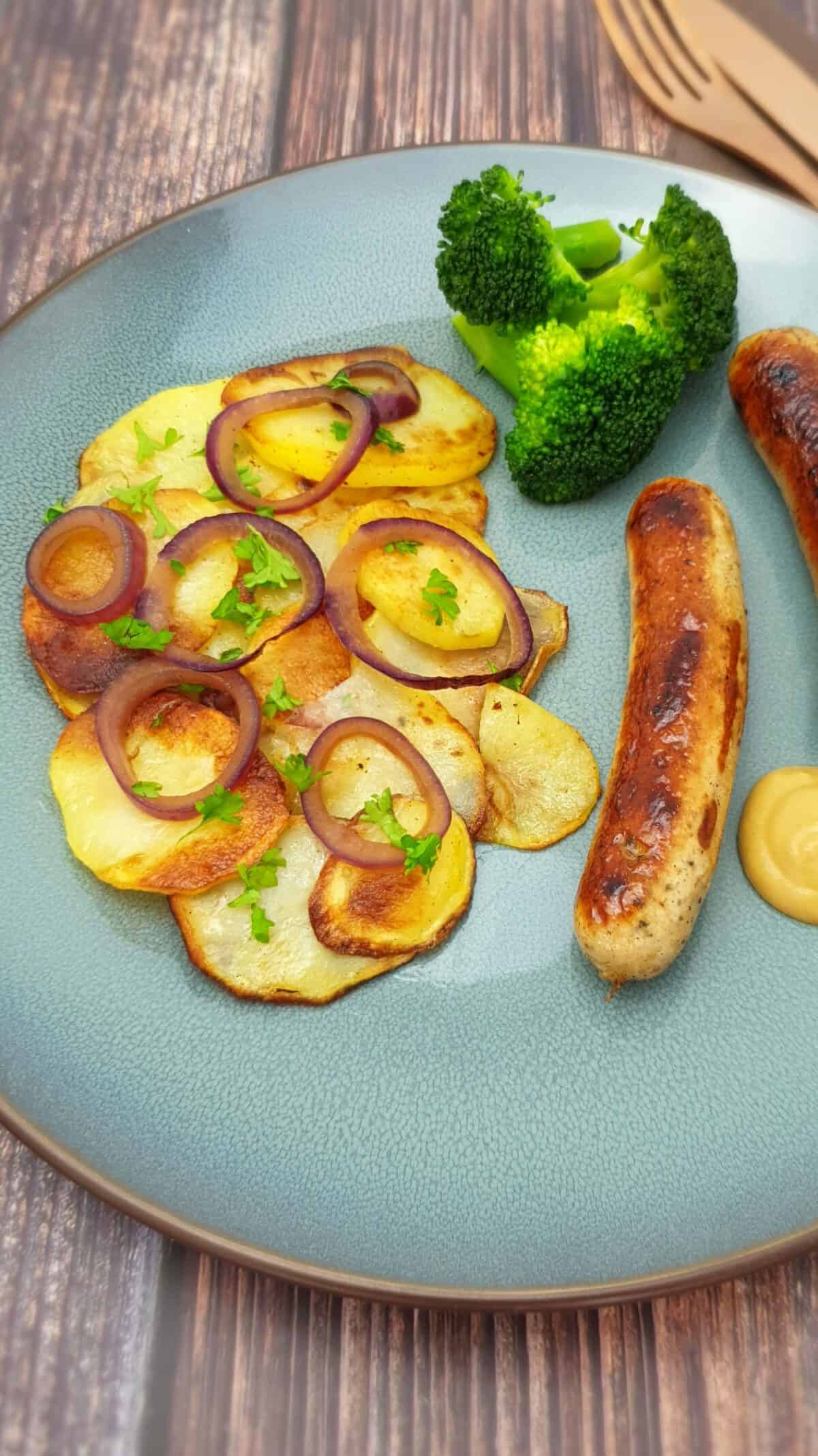 Knusprige Bratkartoffeln mit roten Zwiebeln und Bratwurst