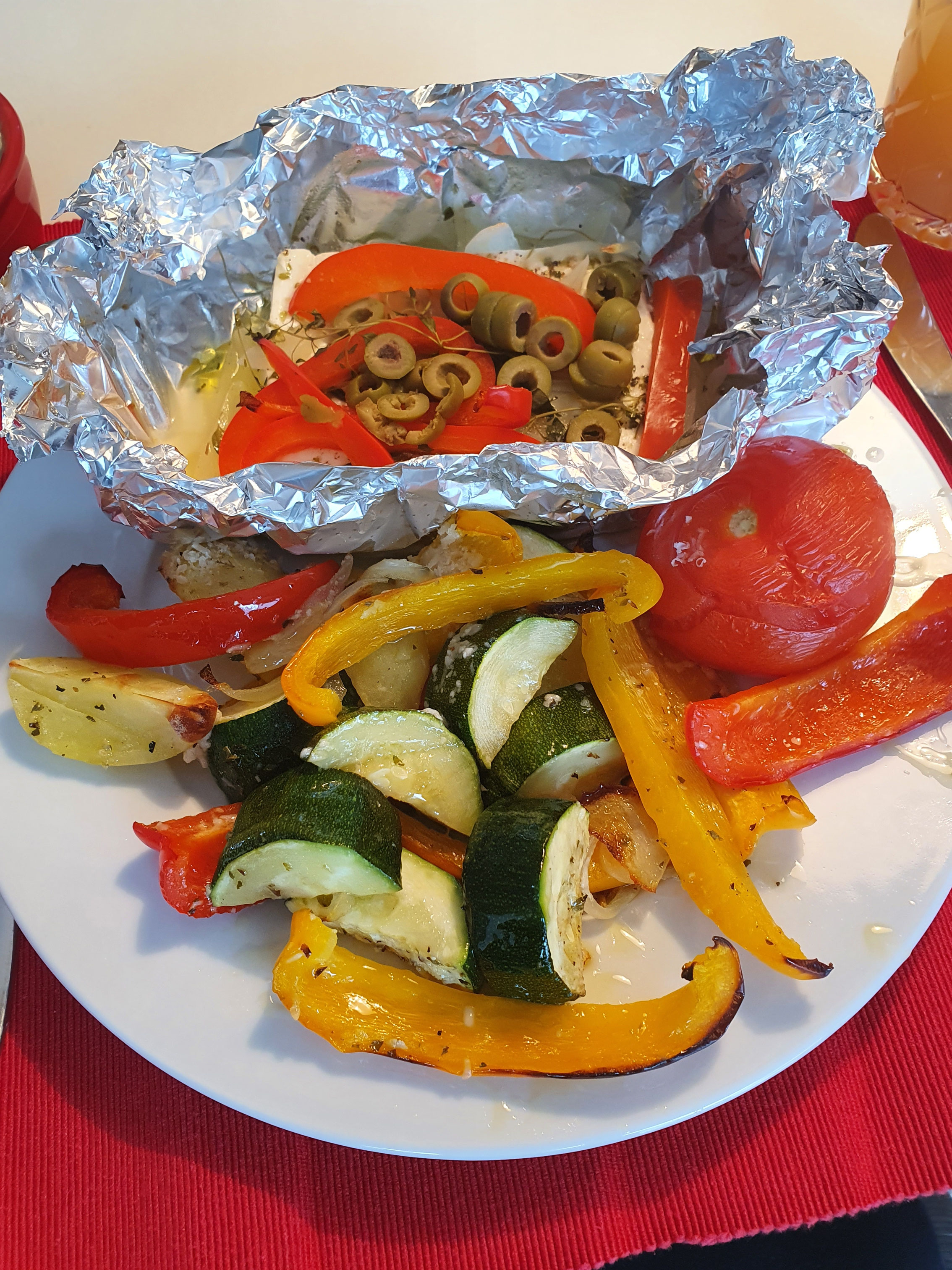 Gebackener Feta in Folie mit Kräutern und geröstetem Ofengemüse.