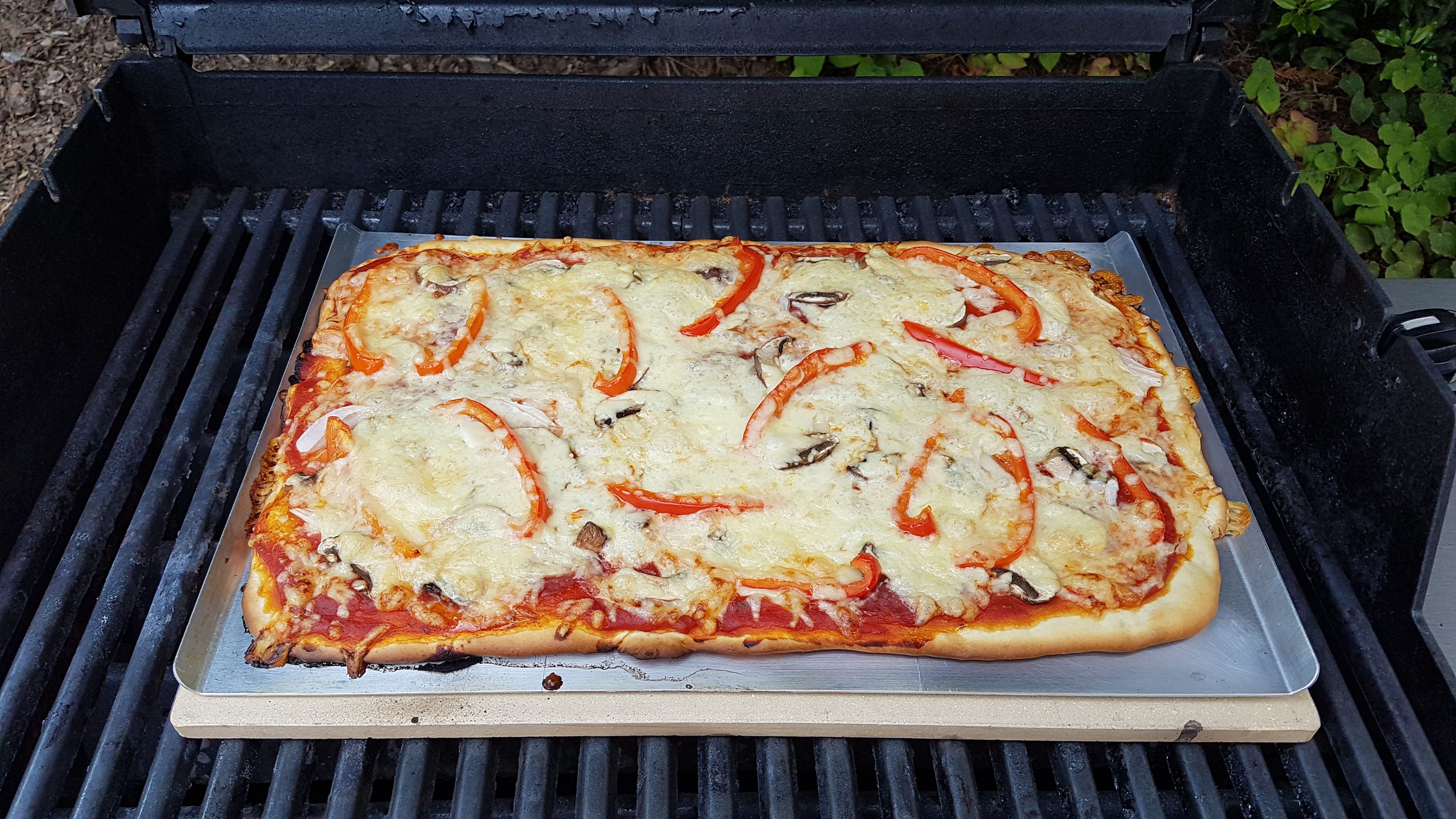 Fertig gebackene Pizza auf dem heißen Stein.