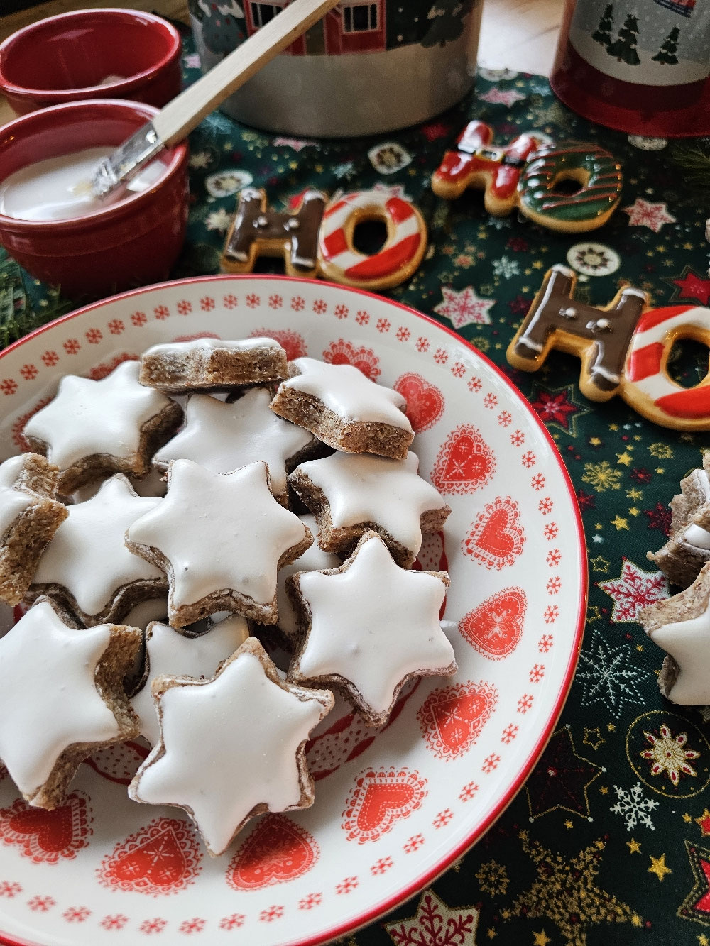 Weiße Zimtsterne auf einer weihnachtlichen Servierplatte.
