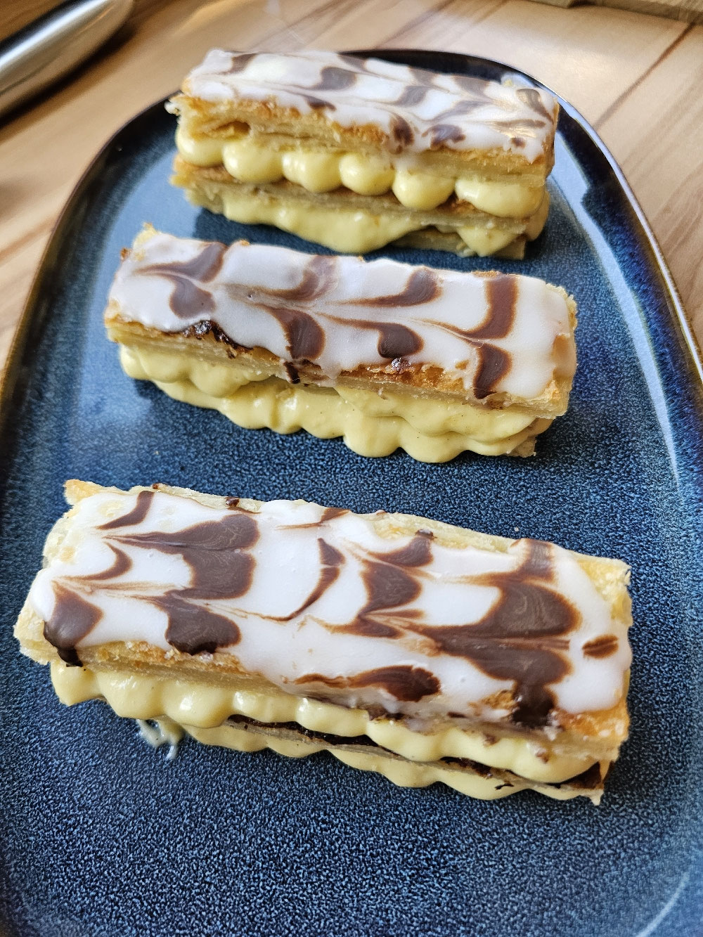 Mille-feuilles mit Vanillecreme und gemustertem Zuckerguss.