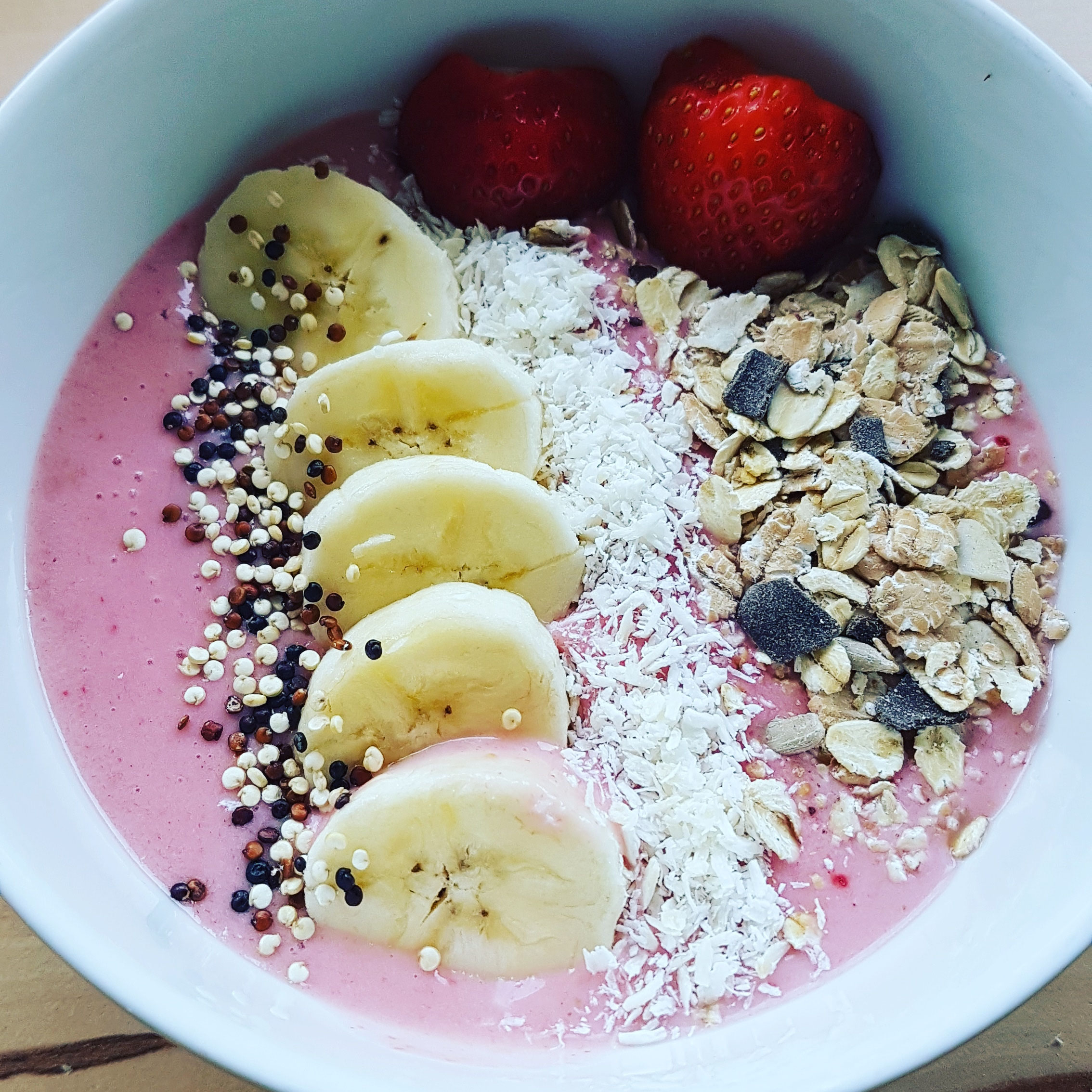 Erdbeer-Bananen-Kokos-Bowl mit fruchtigen Toppings.