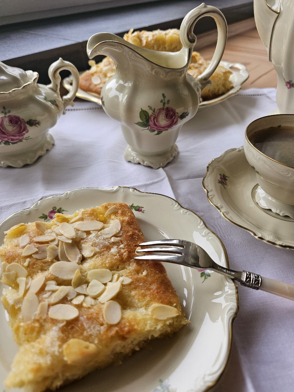 Goldbrauner Butterkuchen mit Mandelblättchen auf einem Teller.