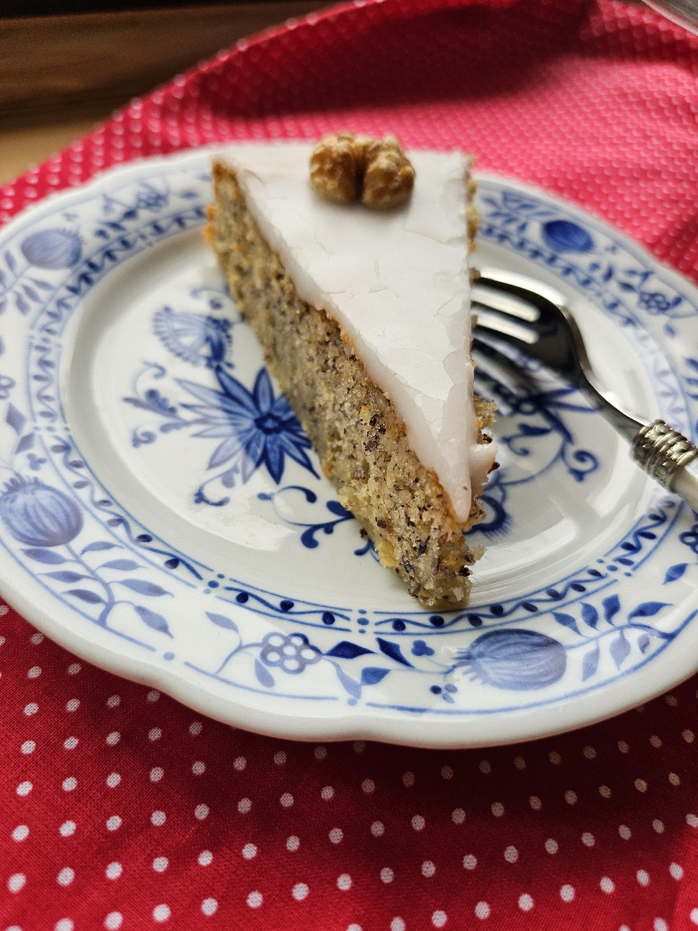 Ein Stück saftige Nusstorte mit Zuckerguss und Walnuss.