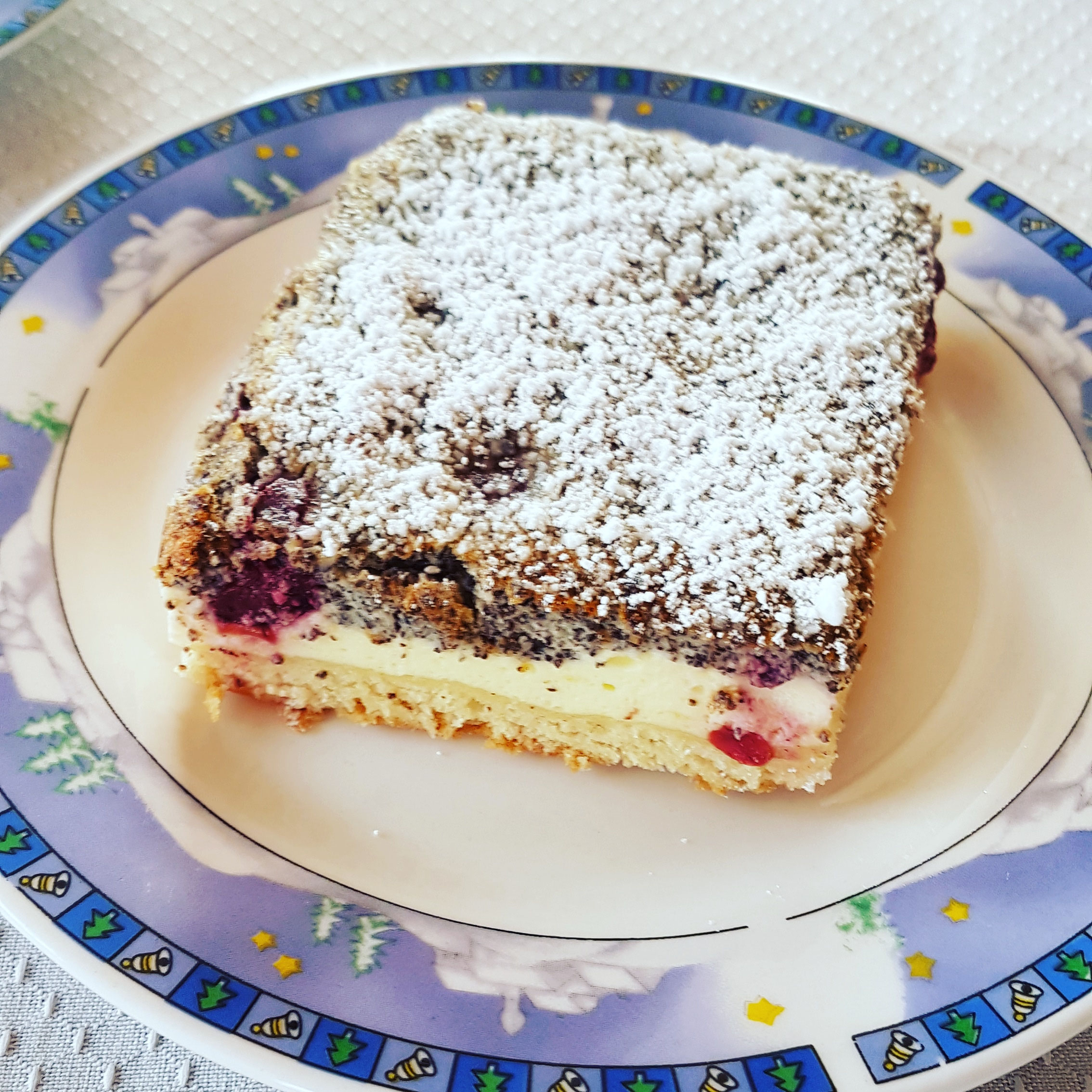 Mohn-Quark-Kuchen mit Kirschen als Stück.