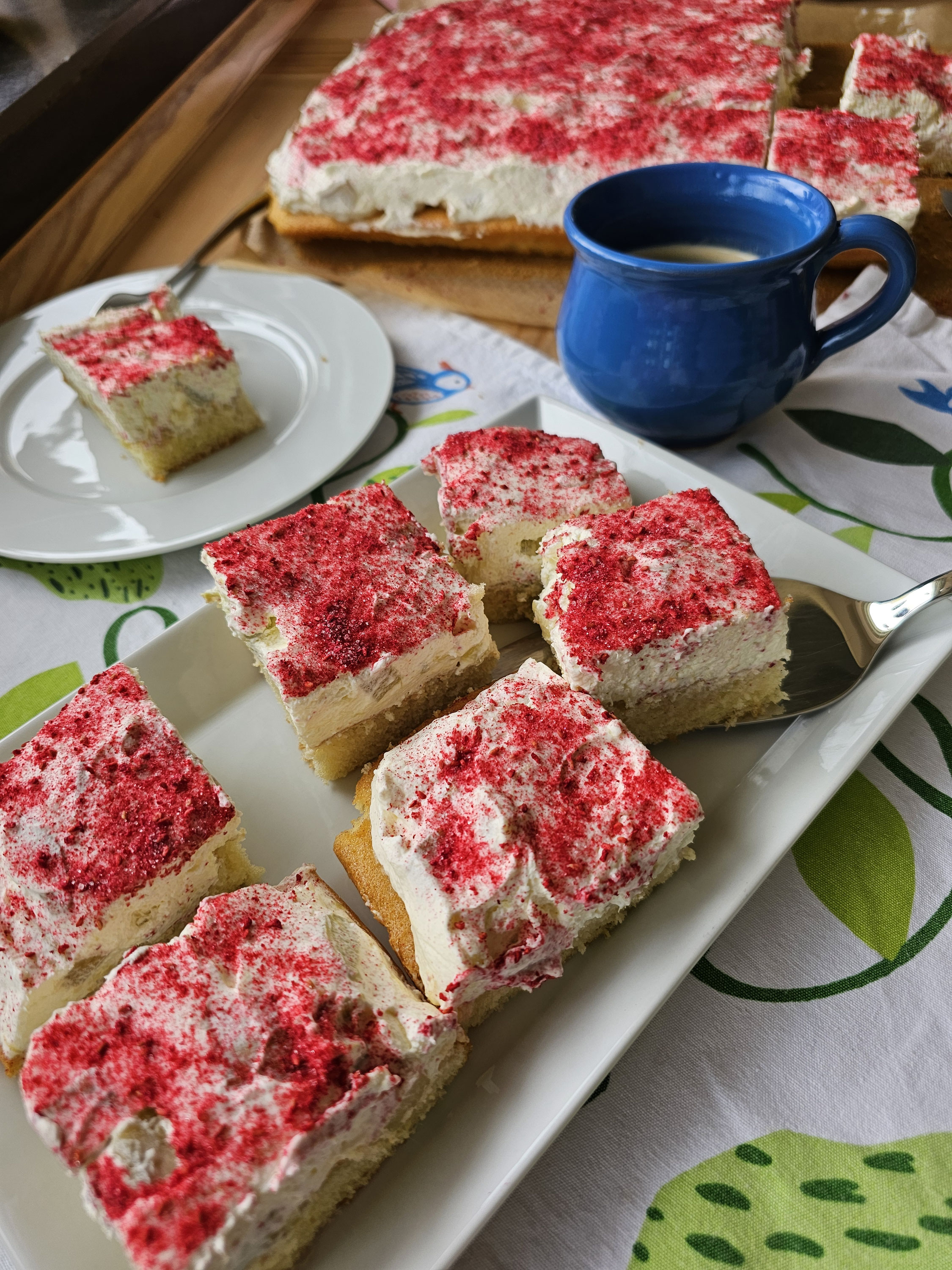 Rhabarber-Schmand-Kuchenstücke mit rotem Himbeerpulver.