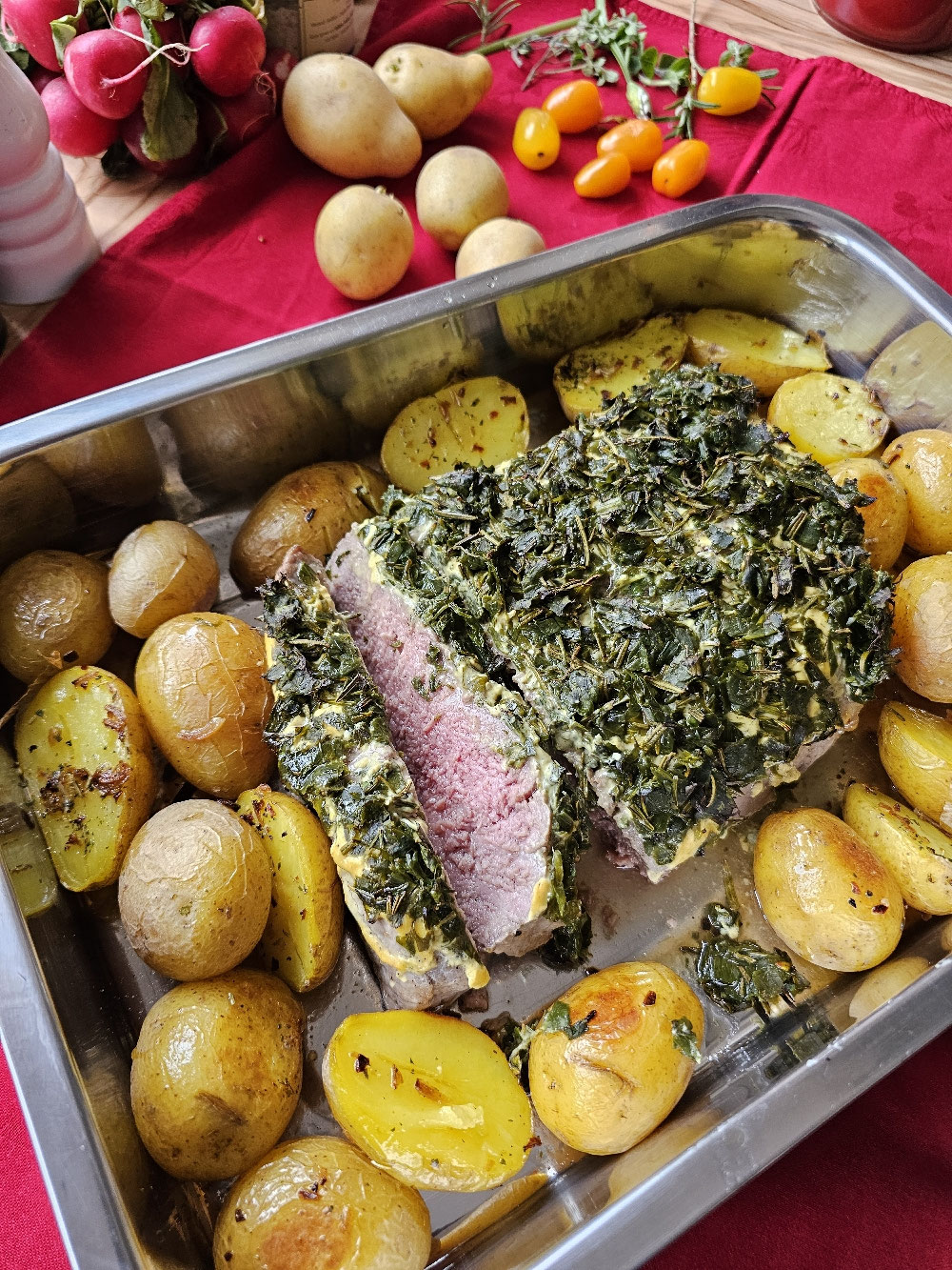 Rosa gebratenes Dijon-Roastbeef mit Kräuterkruste und Ofenkartoffeln.