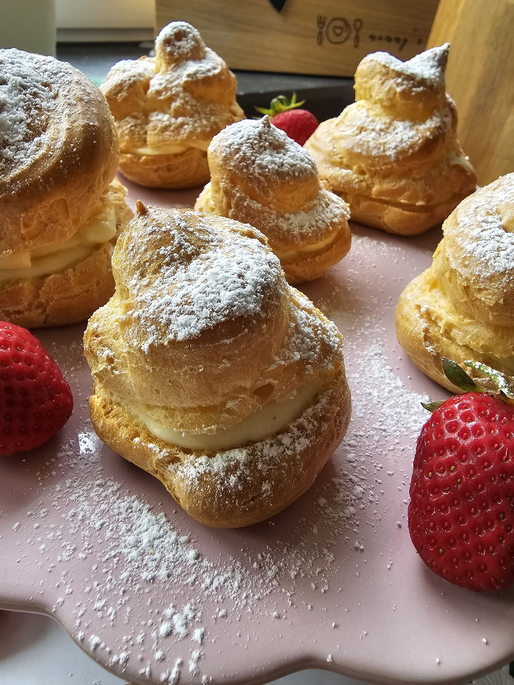 Windbeutel mit Vanillecreme und Puderzucker.