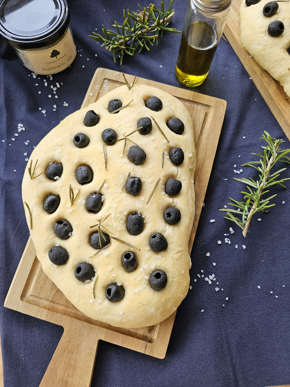 Fertige Oliven-Focaccia mit Rosmarin und grobem Salz.